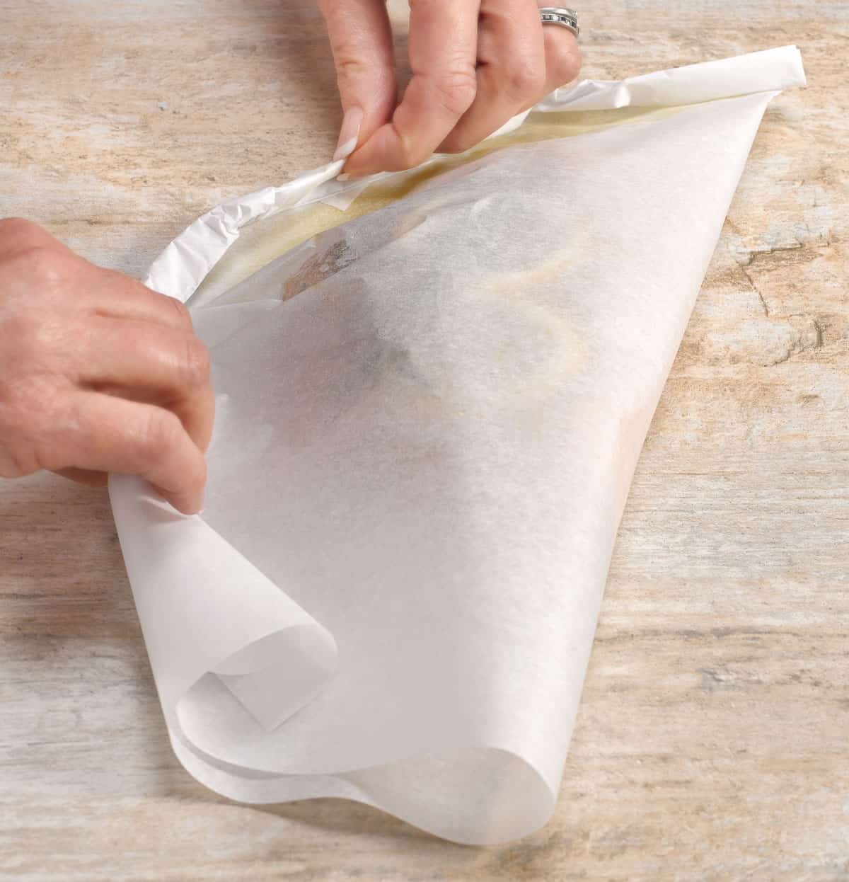 showing how to roll fish inside parchment paper