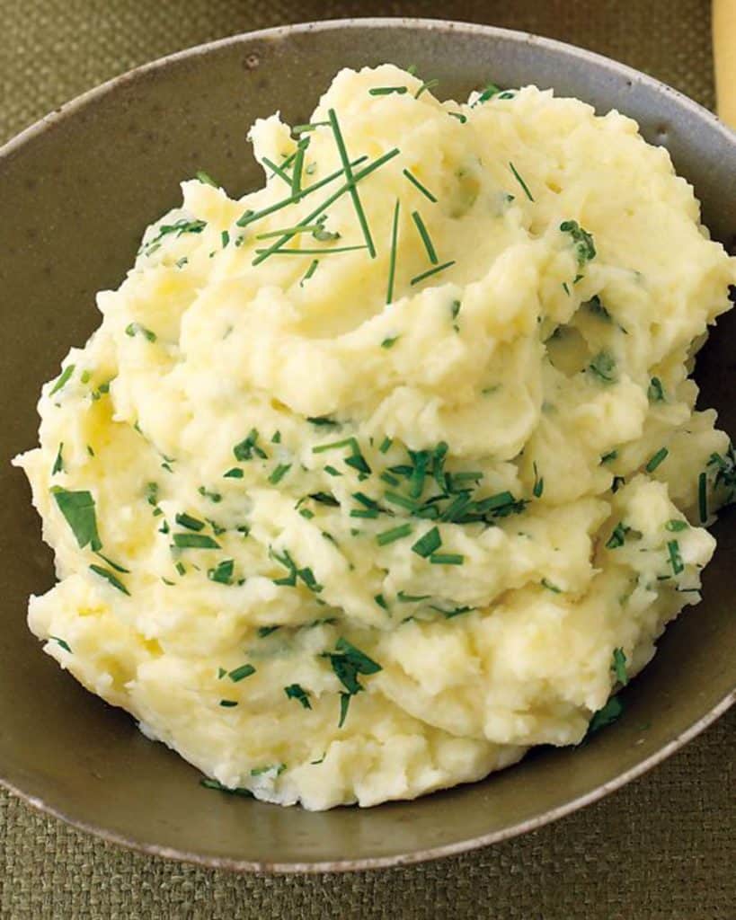 Brown bowl filled with Mashed Potatoes with Parsley and Chives