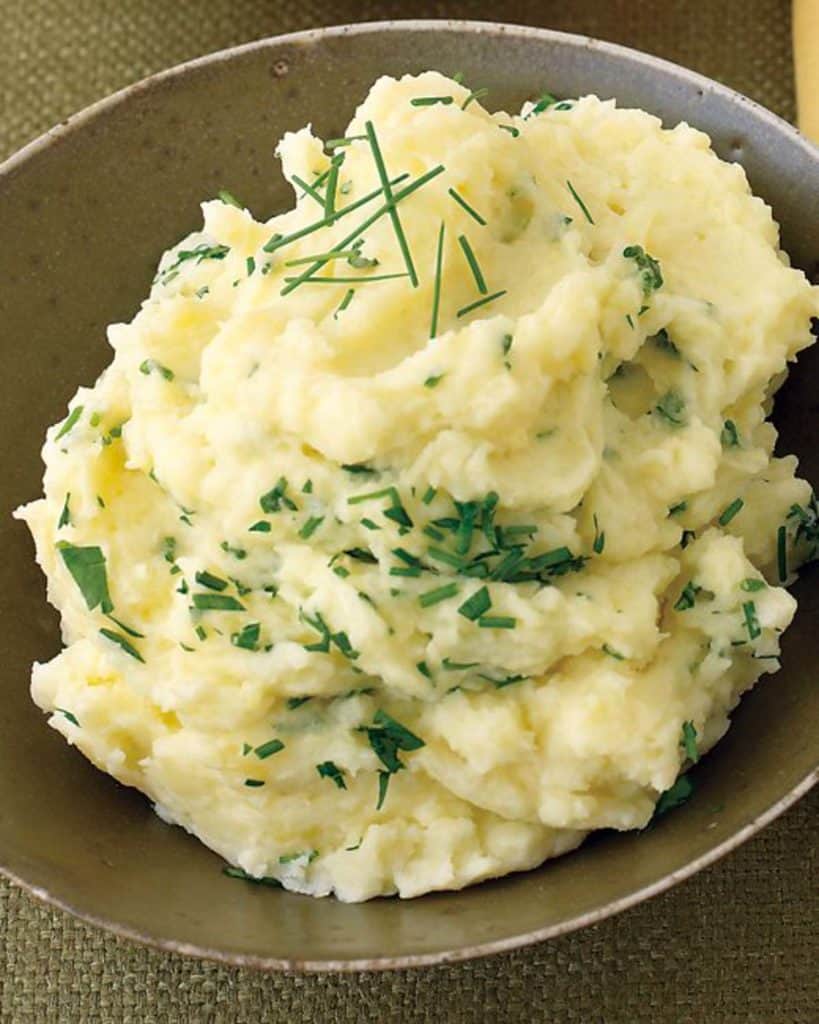 Brown bowl filled with Mashed Potatoes with Parsley and Chives