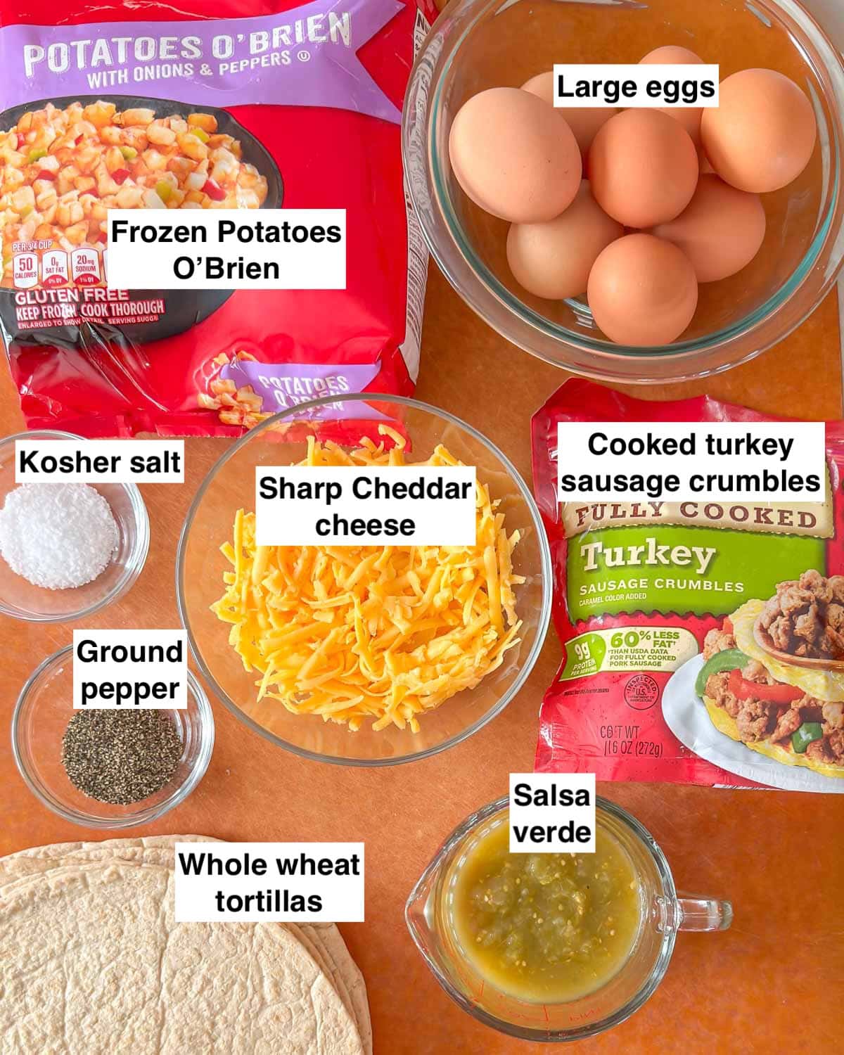 8 ingredients in Meal Prep Breakfast burrito on a cutting board and labeled.