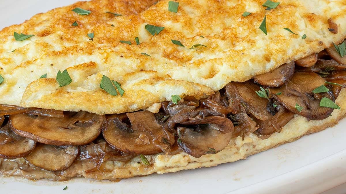 Close up view of mushroom and onion stuffing in omelet showing texture and moistness.
