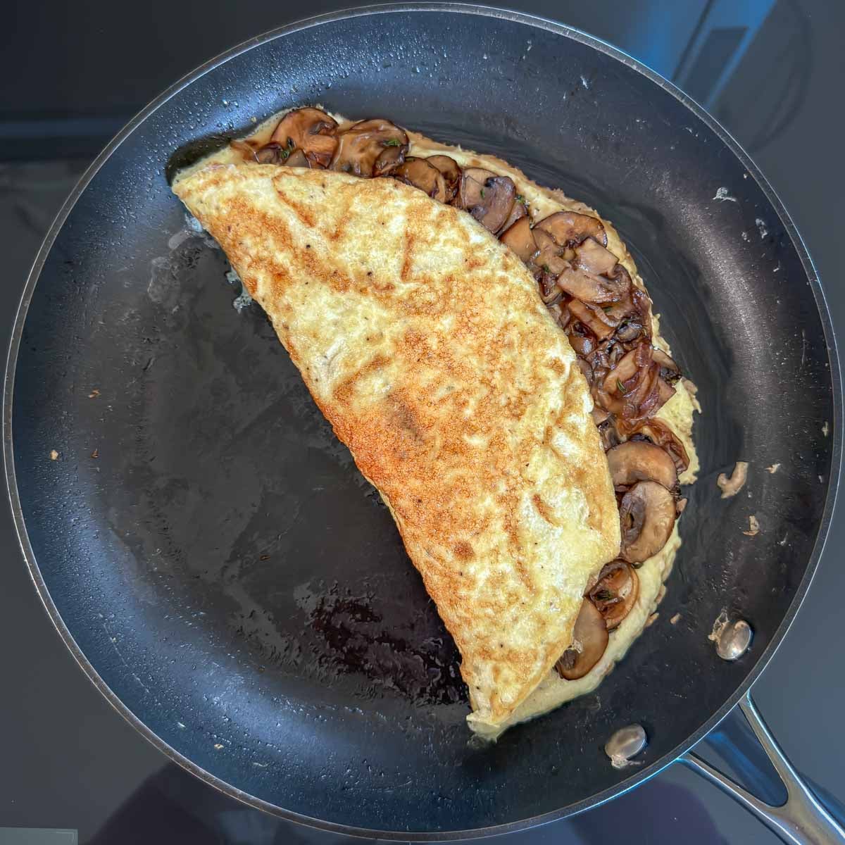 Folded mushroom omelet in a skillet, ready to serve.