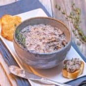 Blue bowl filled with Mushroom Pâté, with toasted baguette slices on the side