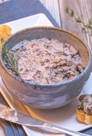 Blue bowl filled with Mushroom Pâté, with toasted baguette slices on the side
