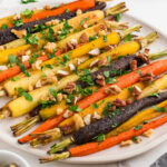 Oven roasted carrots on a white platter.