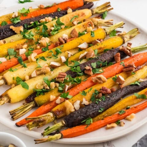 Oven roasted carrots on a white platter.