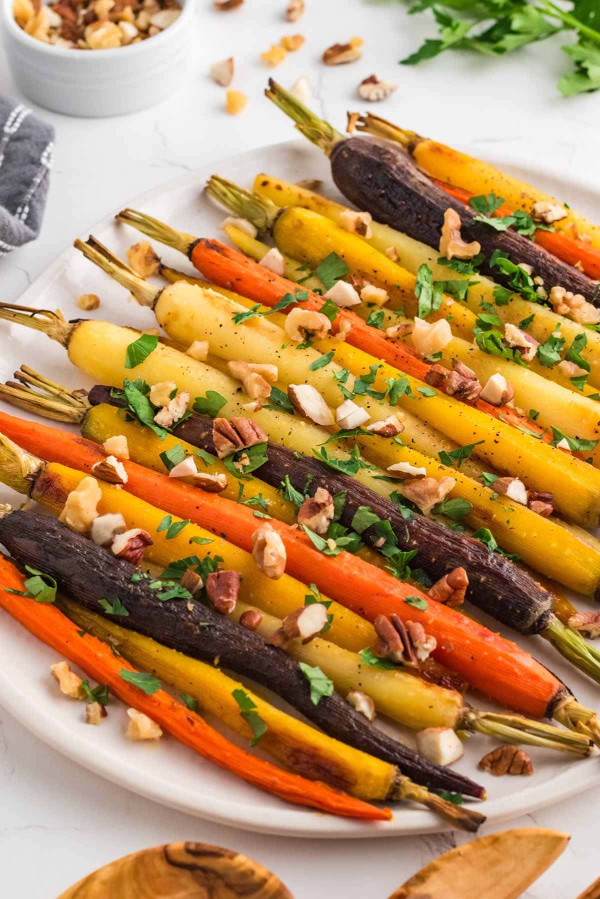 Roasted carrots in oven on a platter garnished with fresh herbs.