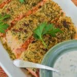 close up overhead showing 3 slices of Parmeasan Crusted Salmon with a bowl of Herb Mayo