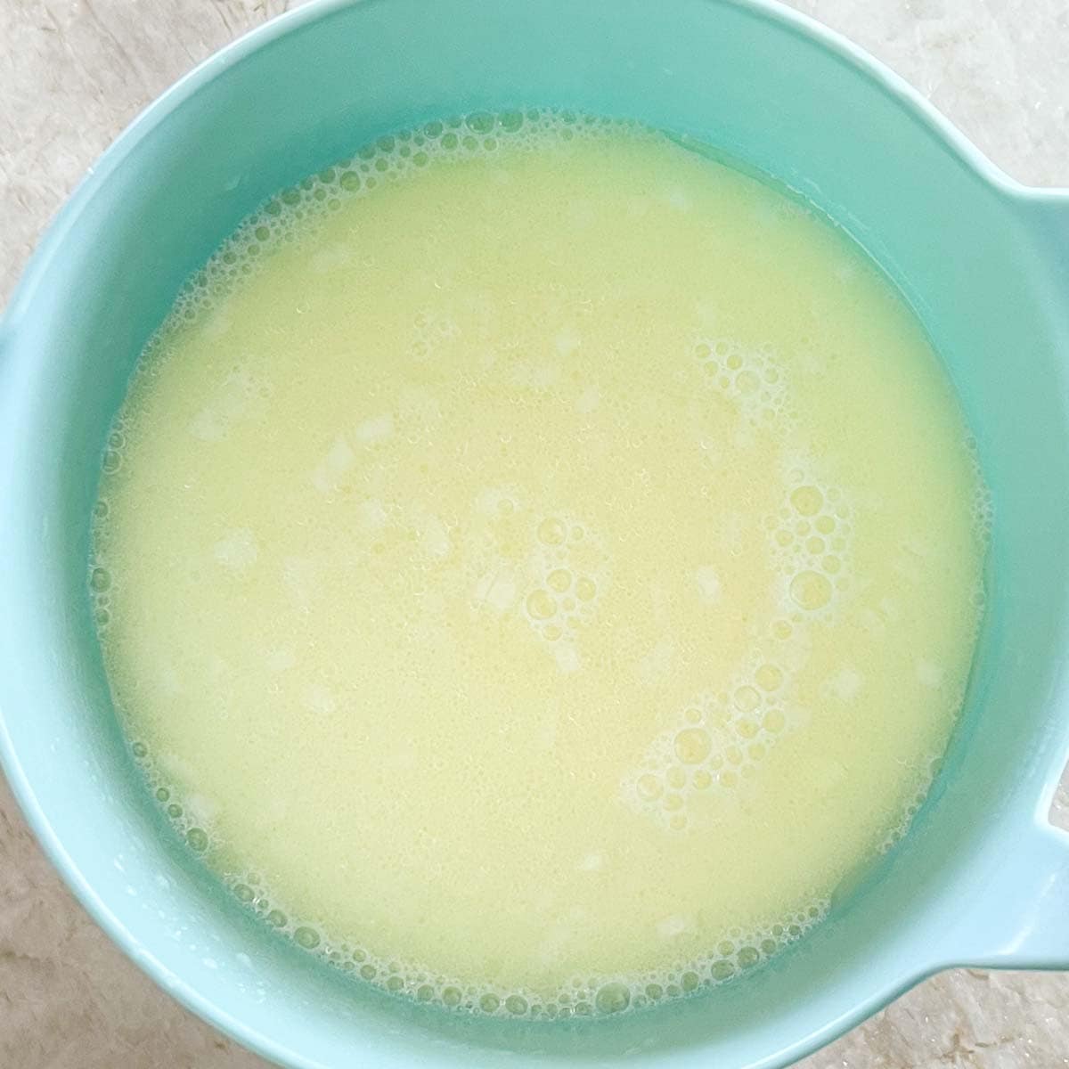 overhead of bowl holding wet ingredients for Parmesan Cornbread with Buttermilk