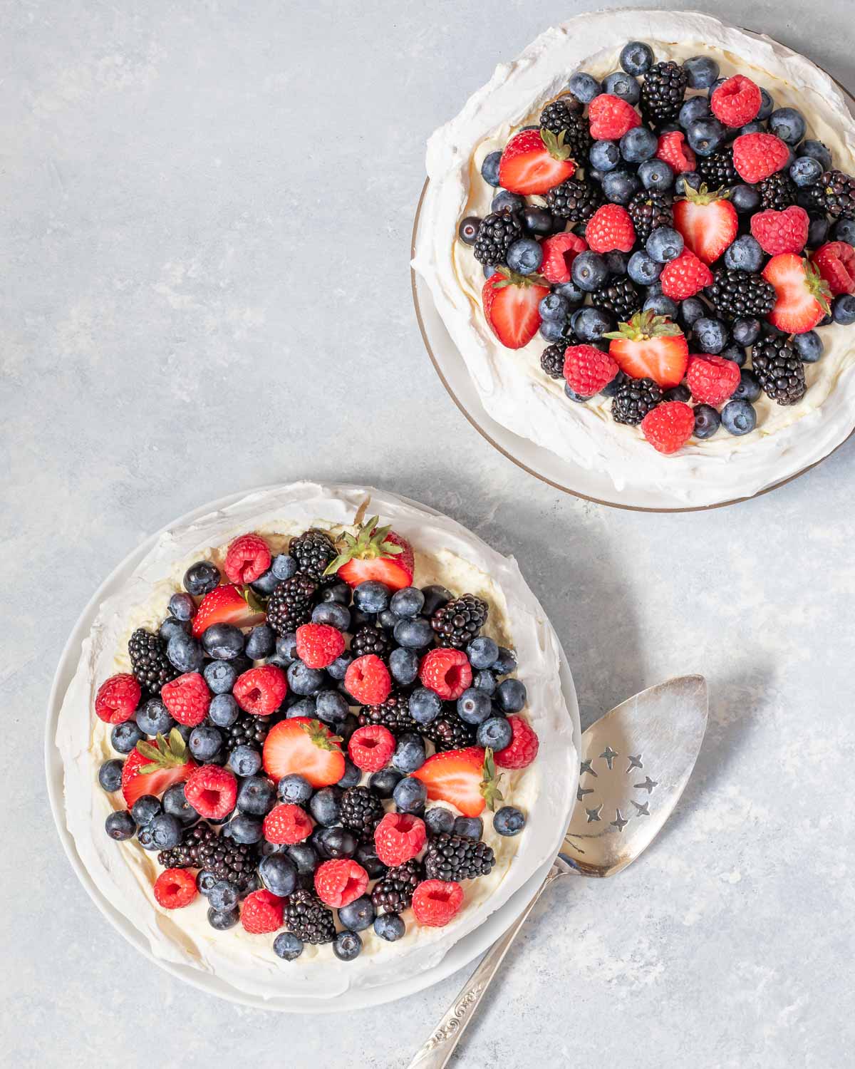 Overhead of two Pavlovas topped with fresh berries