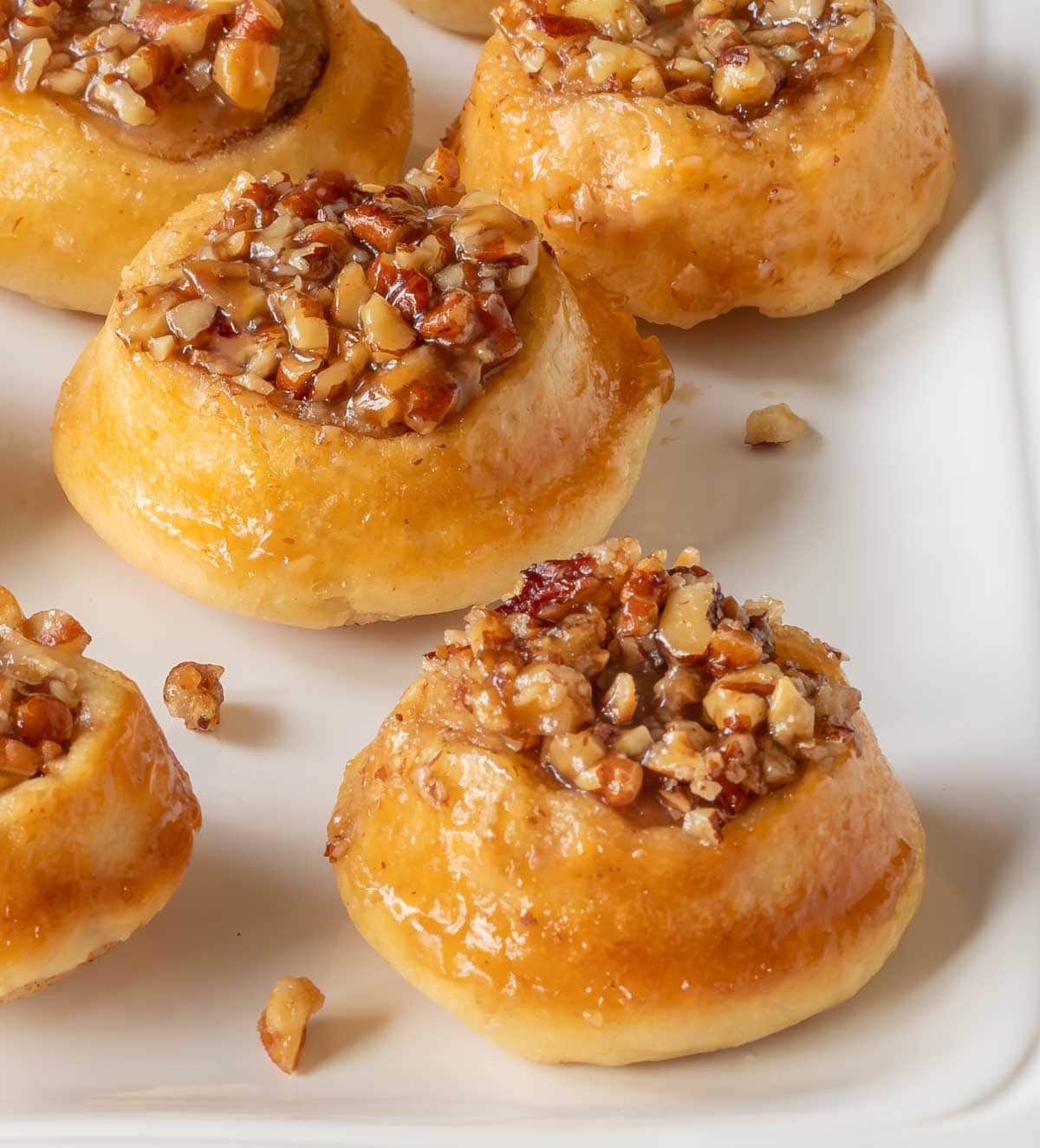 close up of a white platter holding mini pecan rolls