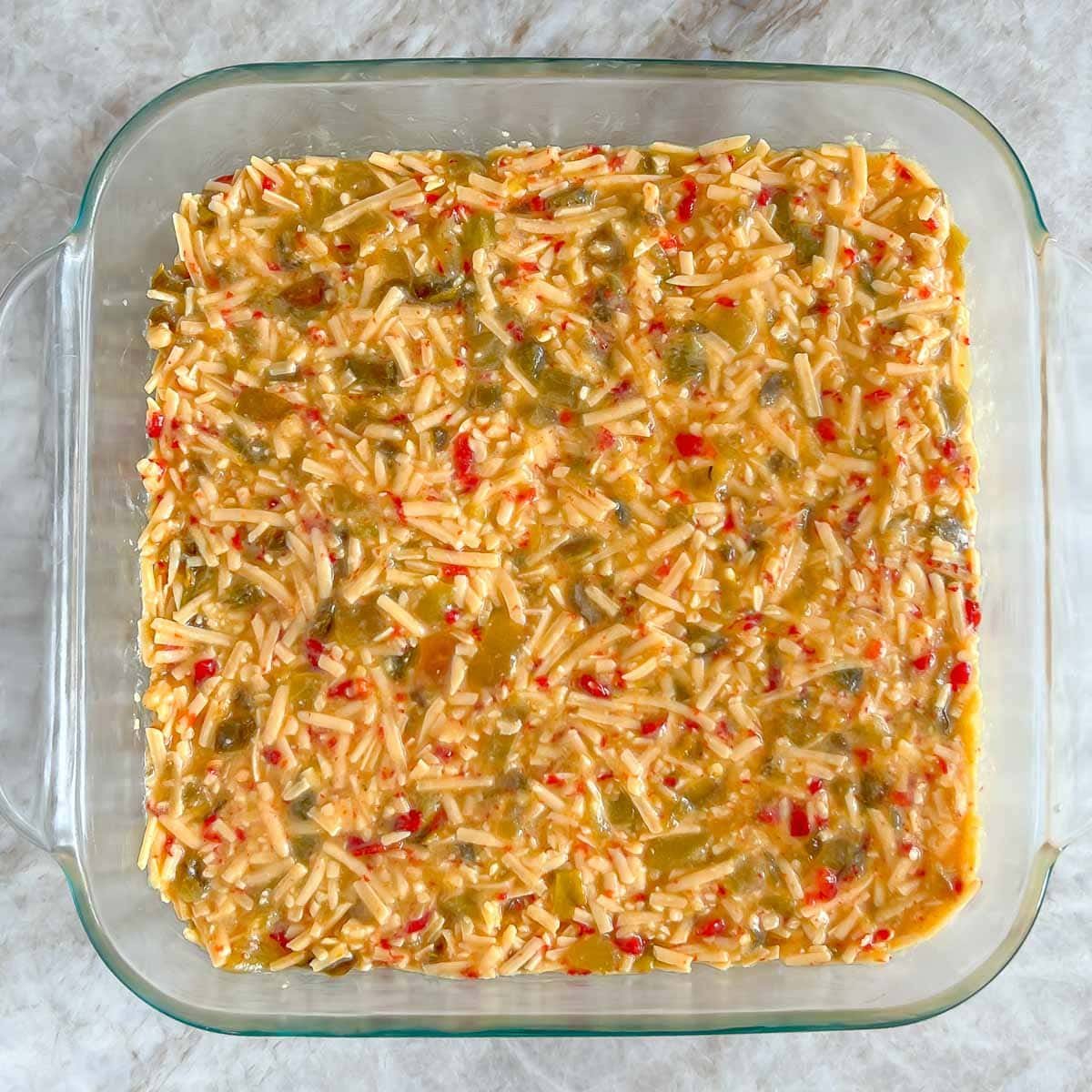 8 by 8 inch baking dish filled with the cheese mixture, showing the smooth top