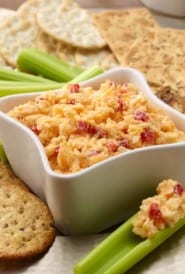 Pimiento Cheese Spread in a white bowl with celery sticks and crackers