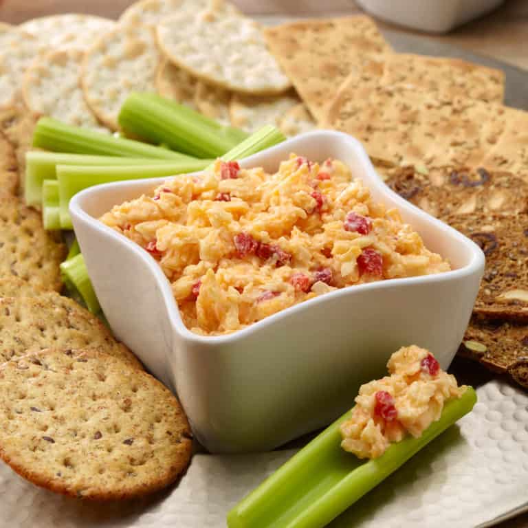 Pimiento Cheese Spread in a white bowl with celery sticks and crackers