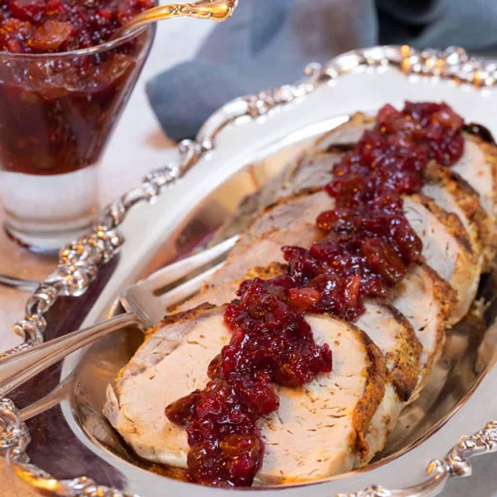 Silver platter with slices of Roast Pork Loin with Fruit Conserves