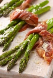 three asparagus bundles tied with a piece of prosciutto
