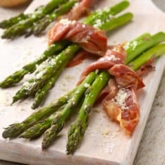 three asparagus bundles tied with a piece of prosciutto