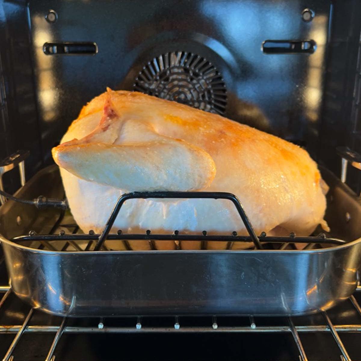 Turkey just beginning to roast in oven, breast side down