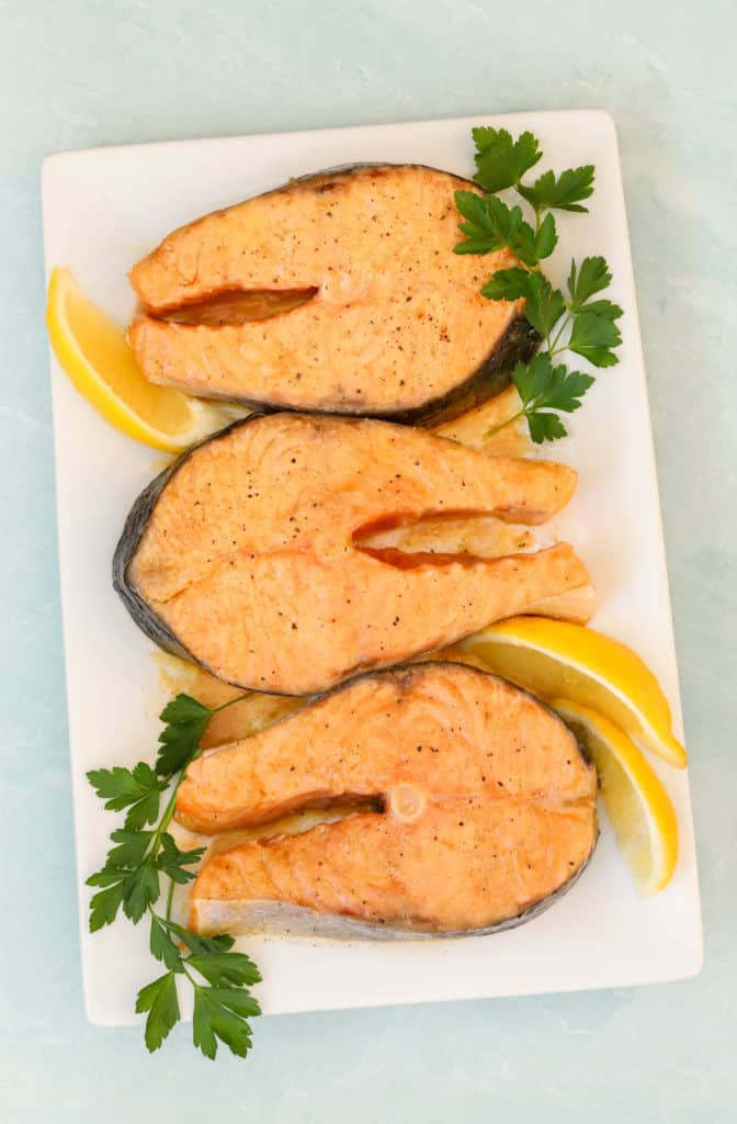 Overhead of 3 Roasted Salmon Steaks on a platter