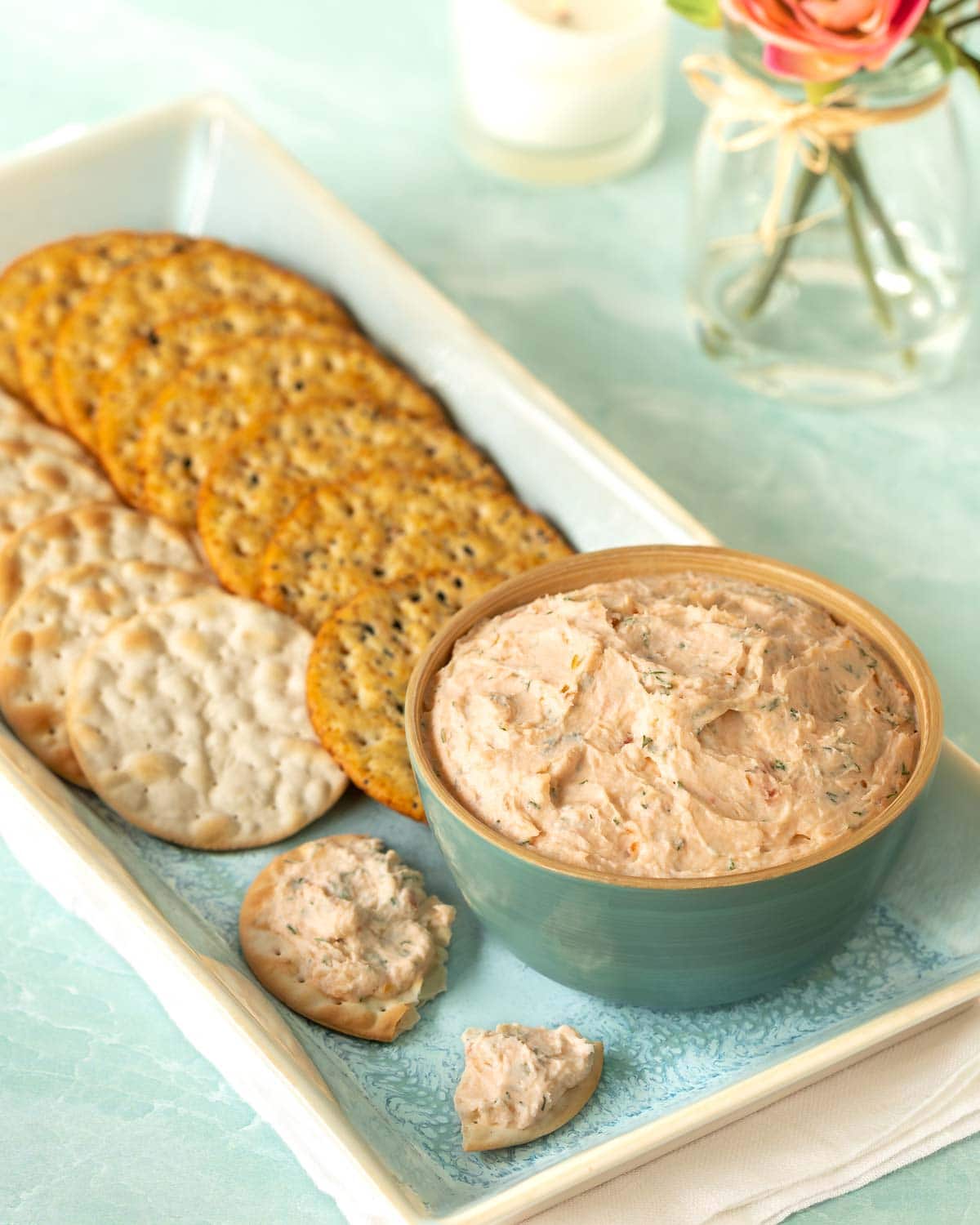 blue bowl holding Smoked Salmon Mouse on a platter that's also holding crackers