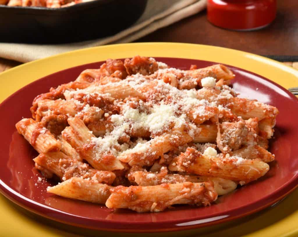red plate filled with Turkey Sausage Penne Marinara