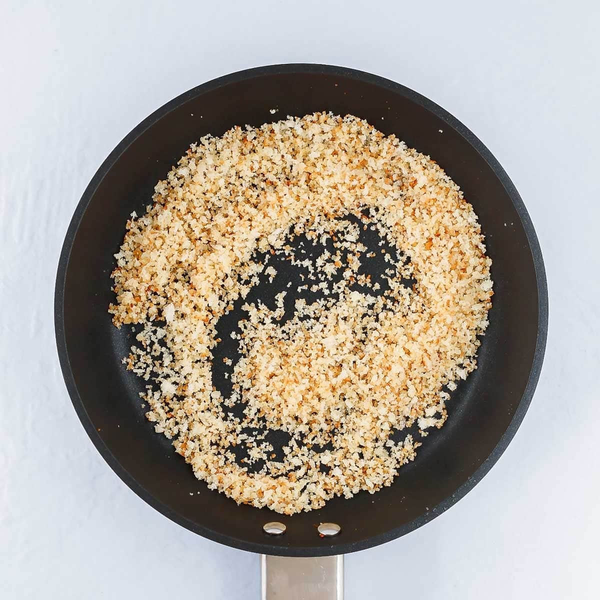 Toasting the breadcrumbs in a skillet.