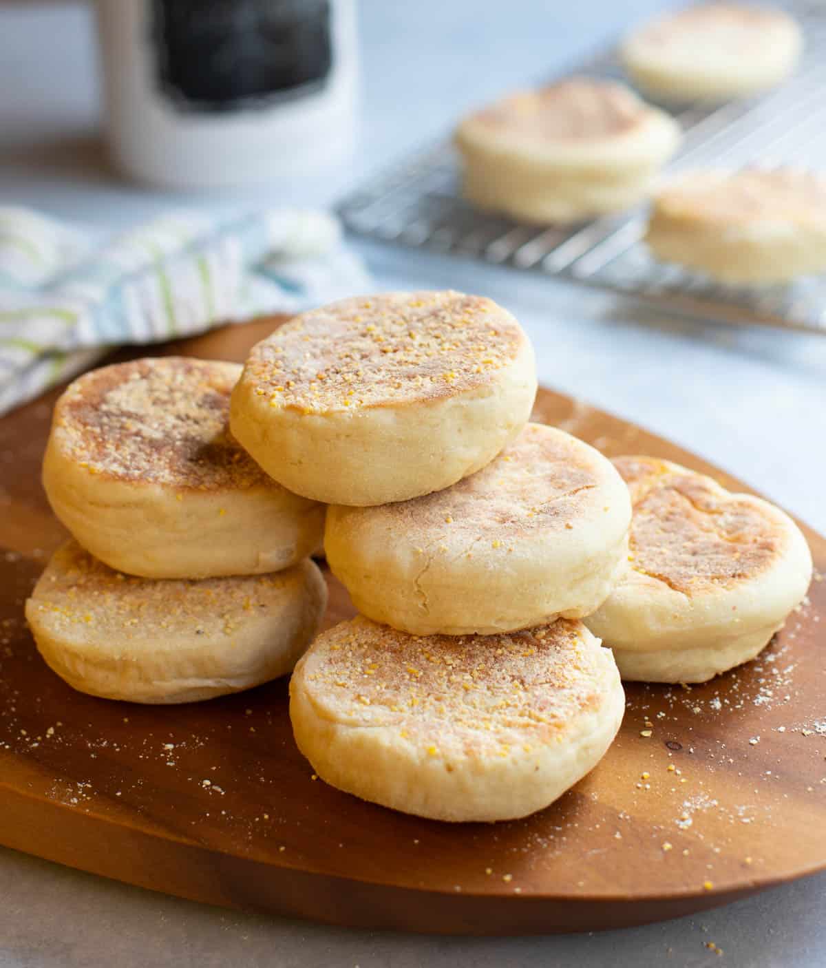 stack of homemade english muffins on cutting board