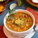 white bowl filled with Southwestern Chicken Soup with Avocado-Cheese Garnish