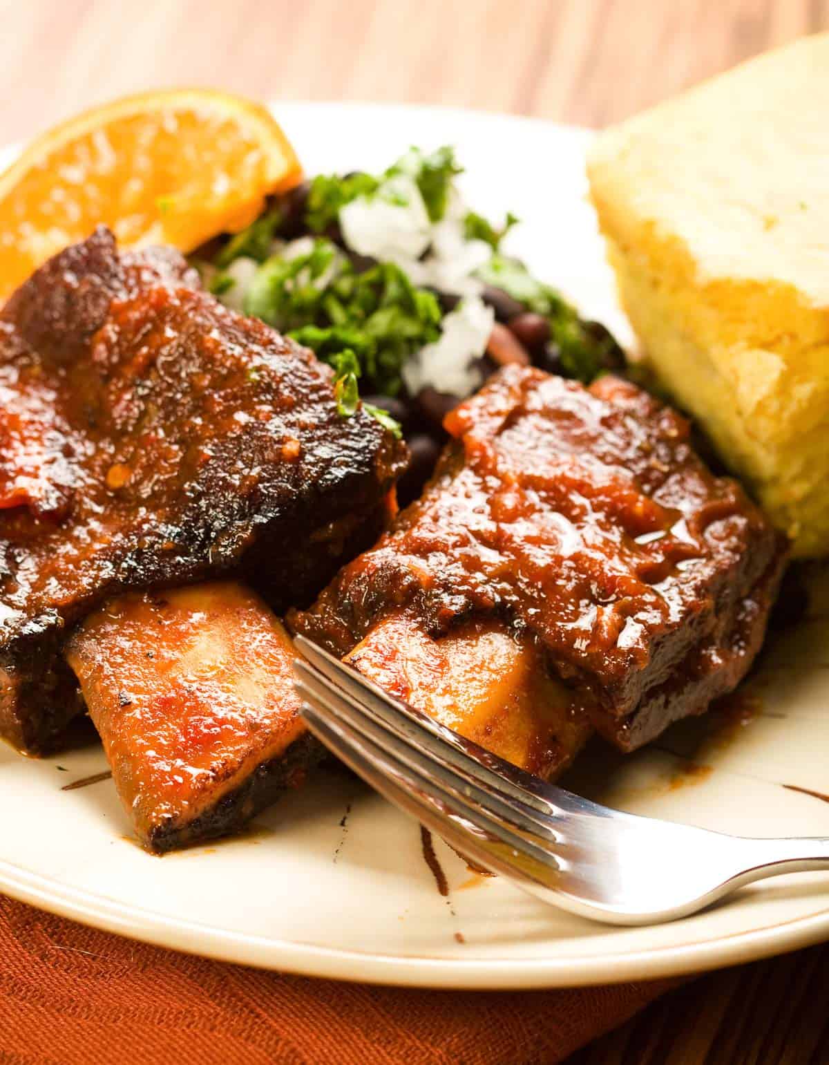 2 beef ribs with spicy sauce on a plate