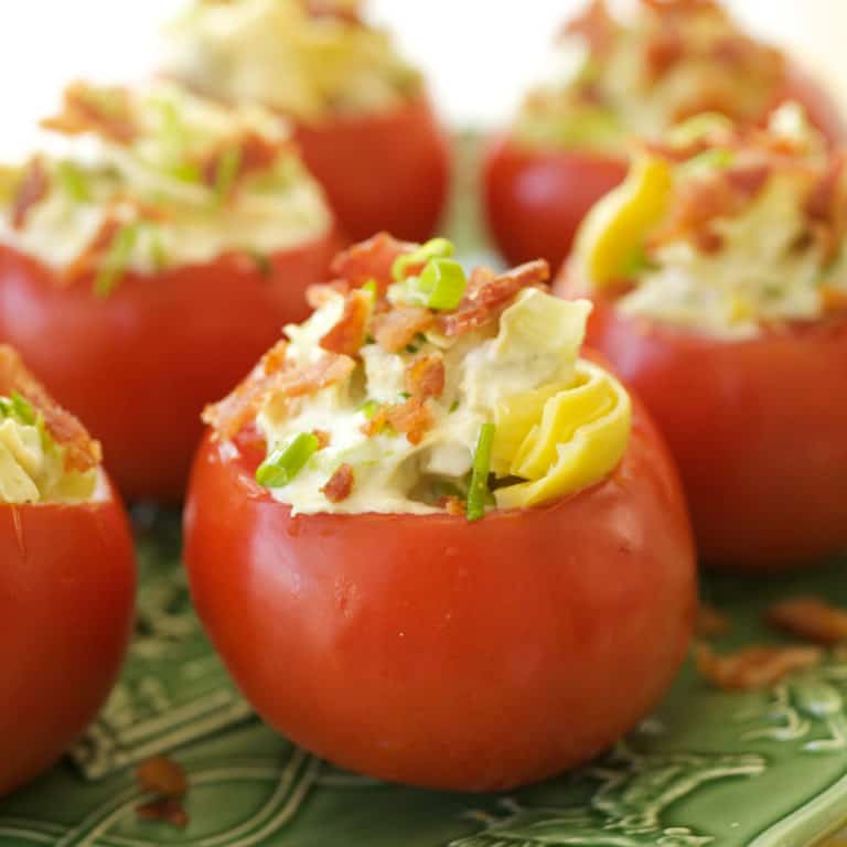 Green platter filled with Tomatoes Stuffed with Artichoke Hearts, Onions and Bacon