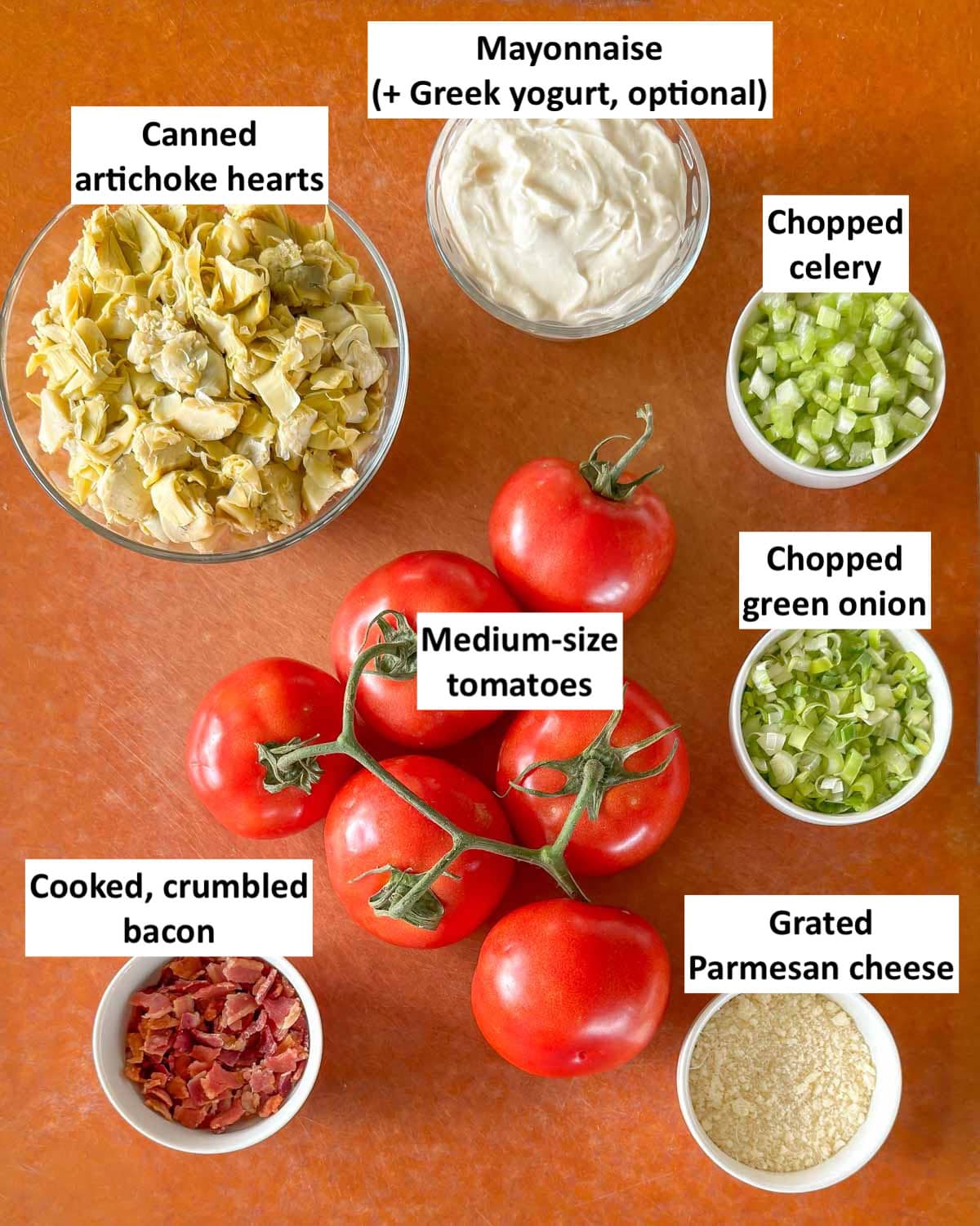 Ingredients to make cold stuffed tomatoes in bowls on a countertop. 