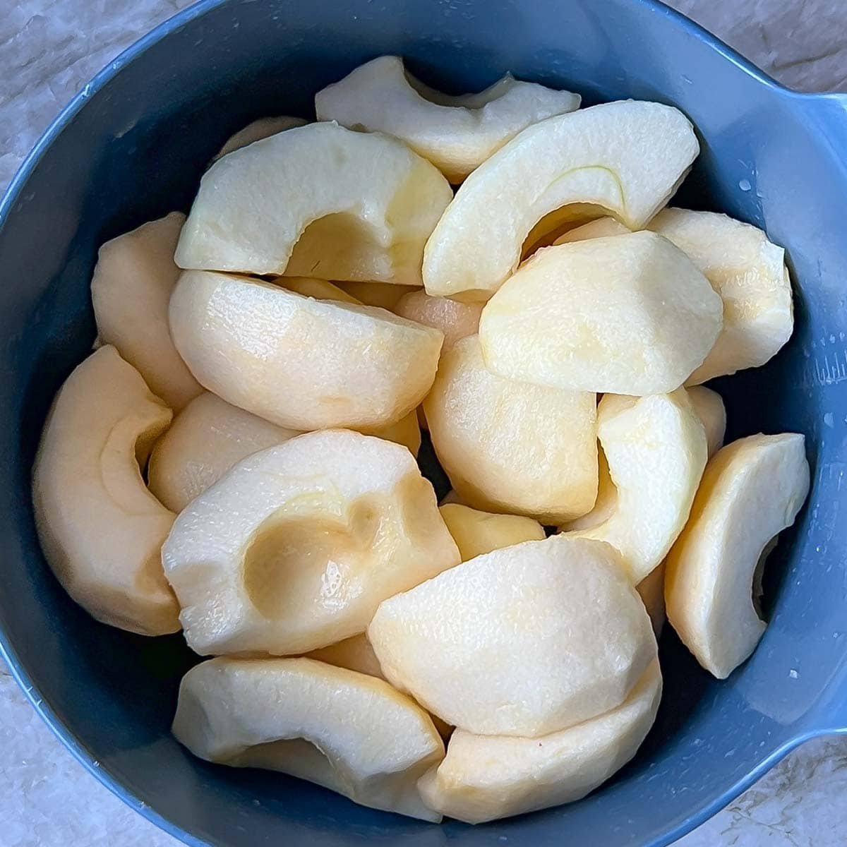 appled prepped for Tarte Tatin in a blue bowl