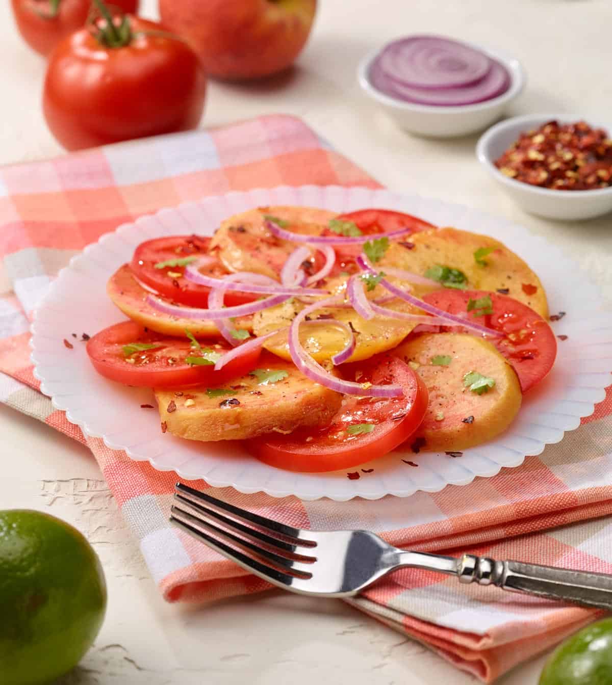 Round white plate filled with Tomato Peach Salad with Lime Dressing