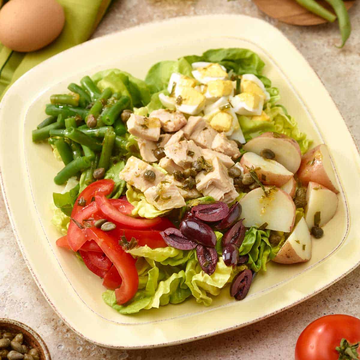 close up of one portion of Tuna Salad Nicoise, arranged on a plate.