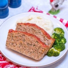 close up of white plate showing two slices of Easy Turkey Meatloaf, with mashed potatos and broccoli