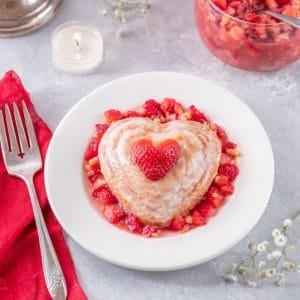 A round white plate holds a single serving of Valentine's Mini Cakes with Strawberry Almond Salsa
