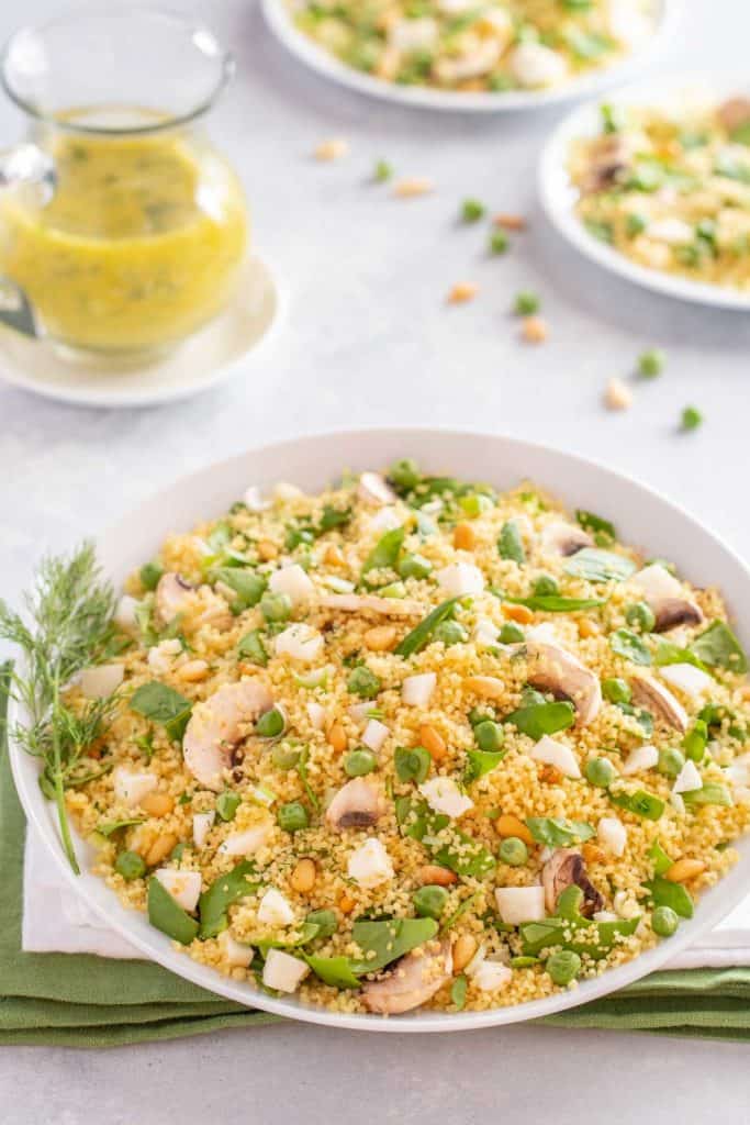 white bowl holding Vegetable Couscous, with Dill Vinaigrette on the side