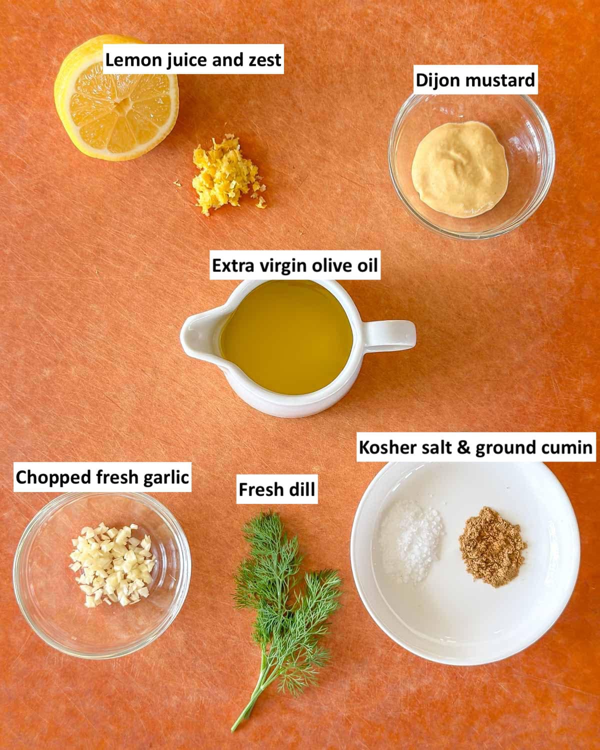 Ingredients for Dill Vinaigrette on a cutting board, prepped and labeled.