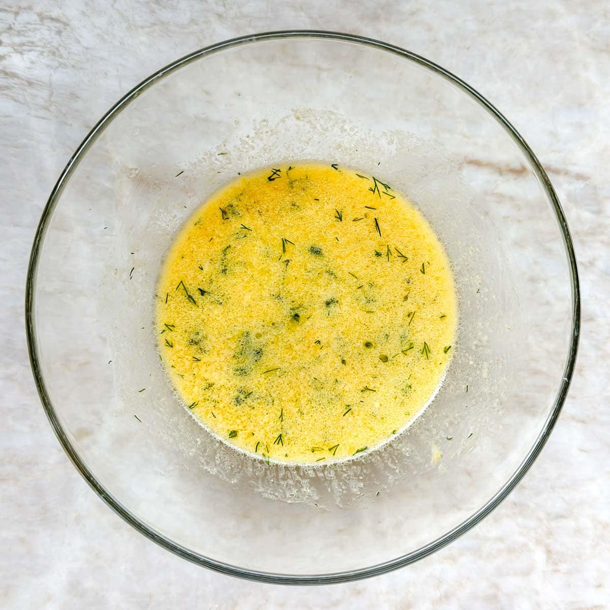 Dill vinaigrette ingredients whisked together in a small bowl.