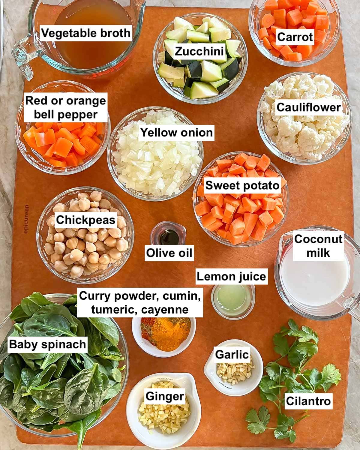 Cutting board holding chopped and measured ingredients for Mixed Vegetable Curry