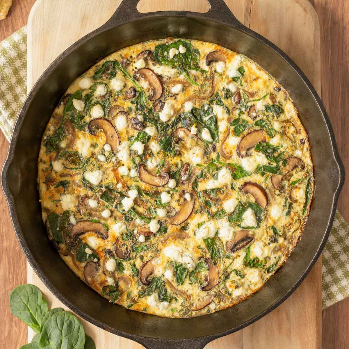 Overhead view of Vegetable Frittata in cast iron skillet set on a cutting board