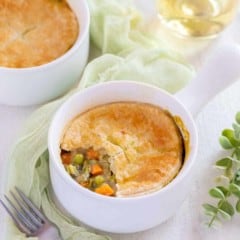 Small white dish holding one serving of Vegetarian Pot Pie with part of the crust removed to show filling