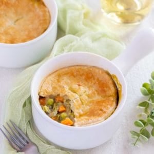 Small white dish holding one serving of Vegetarian Pot Pie with part of the crust removed to show filling